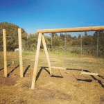 Plaza de juegos de madera San Fernando con columpios y barras de ejercicios