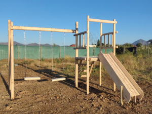 Juegos de madera modelo Talagante con torre elevada, resbalín de madera y dos columpios laterales.